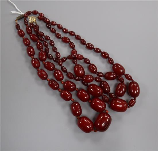 Two graduated simulated cherry amber bead necklaces, including one double strand, gross weight 129 grams, both approx. 48cm.
